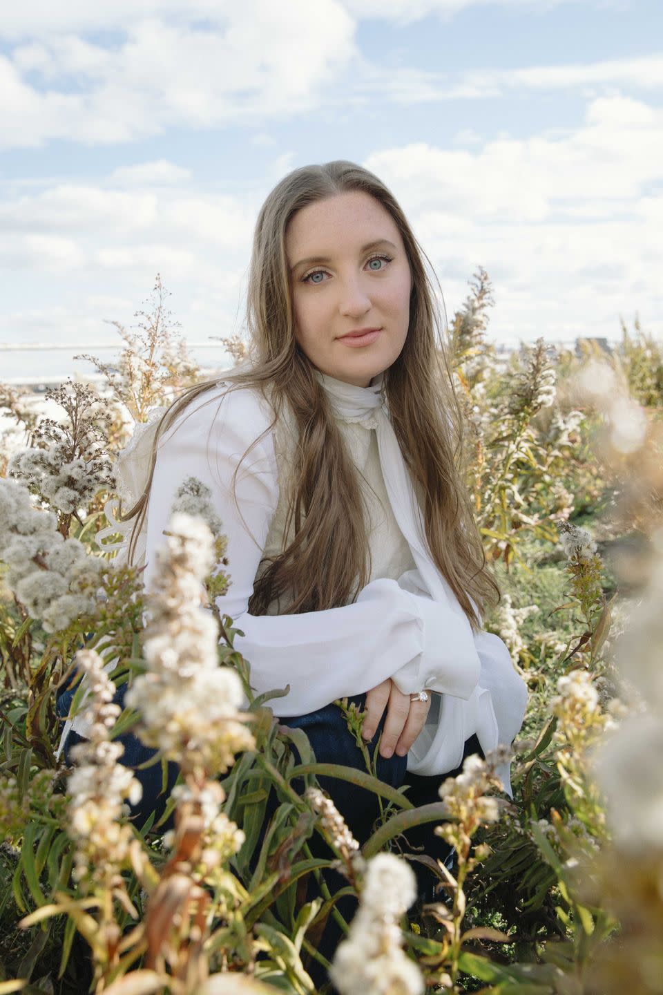 olivia handler stands amid flowers on a roof