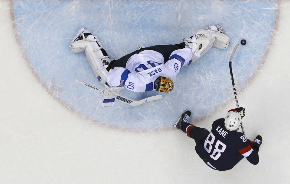 Finland's goalie Tuukka Rask (L) stops Team USA's Patrick Kane on a penalty shot during the first period of their men's ice hockey bronze medal game at the Sochi 2014 Winter Olympic Games February 22, 2014. REUTERS/Mark Blinch (RUSSIA - Tags: SPORT ICE HOCKEY OLYMPICS)