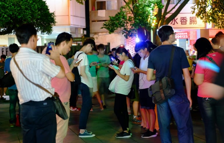 Local gamers play Pokemon Go at the Beitou Park in Taipei on August 23, 2016