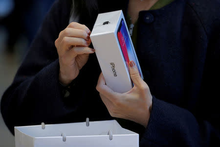 FILE PHOTO: A customer looks at her Apple iPhone X at an Apple store in New York, U.S., November 3, 2017. REUTERS/Lucas Jackson/File Photo