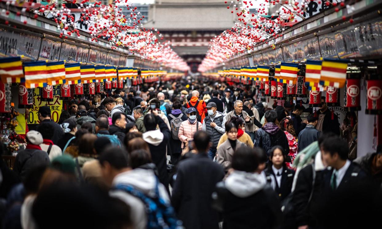 <span>Visitors on the shopping street in Asakusa district near Sensoji Temple, Tokyo.</span><span>Photograph: Philip Fong/AFP/Getty Images</span>