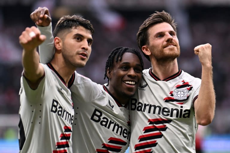 El argentino Exequiel Palacios (izquierda), el neerlandés Jeremie Frimpong (centro) y el alemán Jonas Hofmann celebran un gol durante la victoria contra el Eintracht Fráncfort de la 32ª jornada de Bundesliga, el 5 de mayo de 2024 en Fráncfort. (Kirill KUDRYAVTSEV)