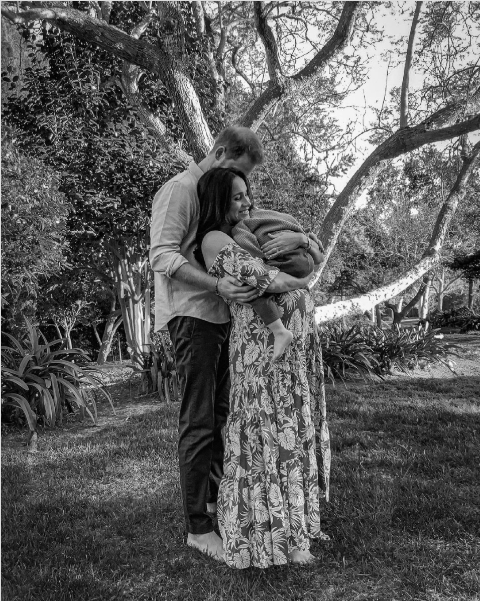 A black and white photo of Prince Harry and a pregnant Meghan Markle who is holding their son, Archie released to announce they're expecting their second child