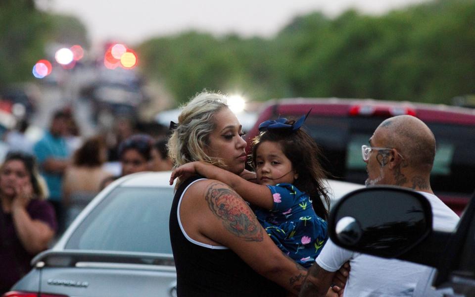 People look on at the scene - KAYLEE GREENLEE BEAL 