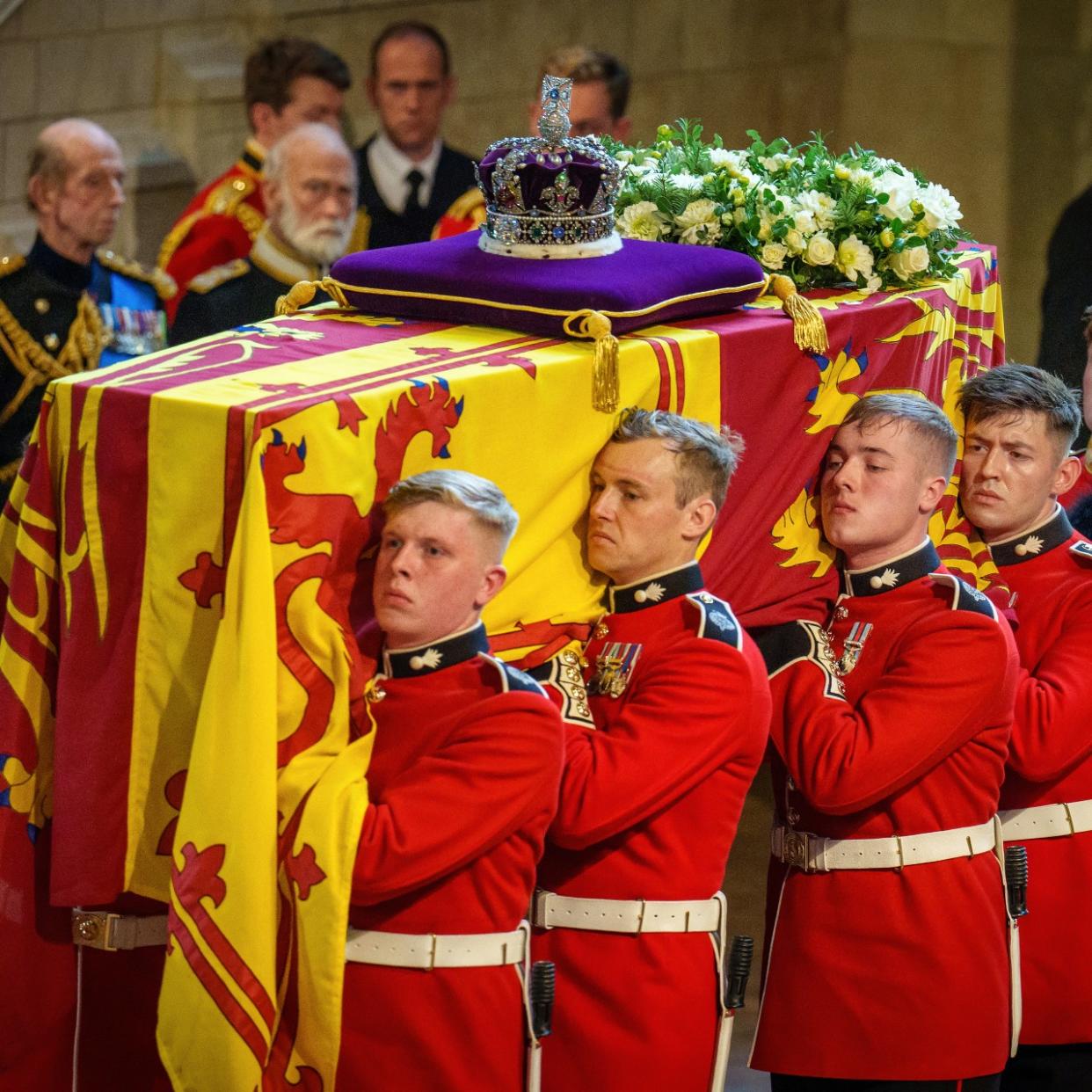  The coffin of Queen Elizabeth II is carried into The Palace of Westminster by guardsmen from The Queen's Company, 1st Battalion Grenadier Guards during the procession for the Lying-in State of Queen Elizabeth II on September 14, 2022 in London, England. 