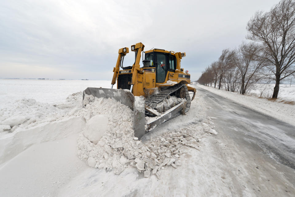 A road sweeping vehicle clears snow from the road near the city of Vrbas, northern Serbia, Saturday, Feb. 1, 2014. Snow drifts formed by stormy winds have blocked two passenger trains and dozens of vehicles in northern Serbia, while authorities closed down several roads and a border crossing with Hungary. The state railway company says two trains to and from Hungary got stuck early on Saturday because of meters-high snow piles that formed on the railway. Emergency officials say several dozen passengers from the trains will be evacuated. (AP Photo/Darko Dozet) SERBIA OUT