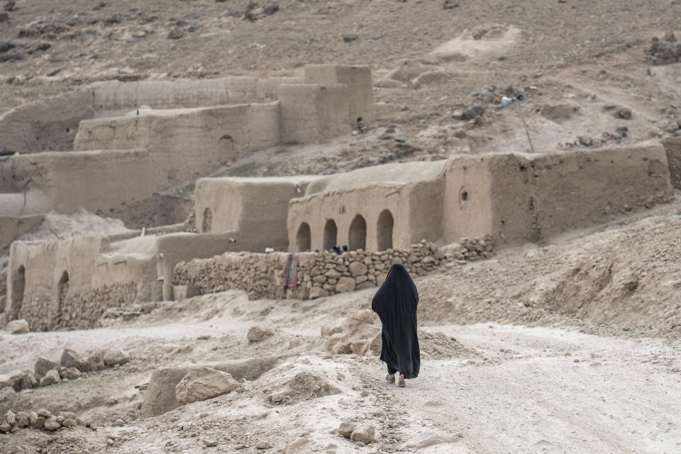 A woman walks towards a village in a remote region of Afghanistan, on Saturday, Feb. 25, 2023. (AP Photo/Ebrahim Noroozi)