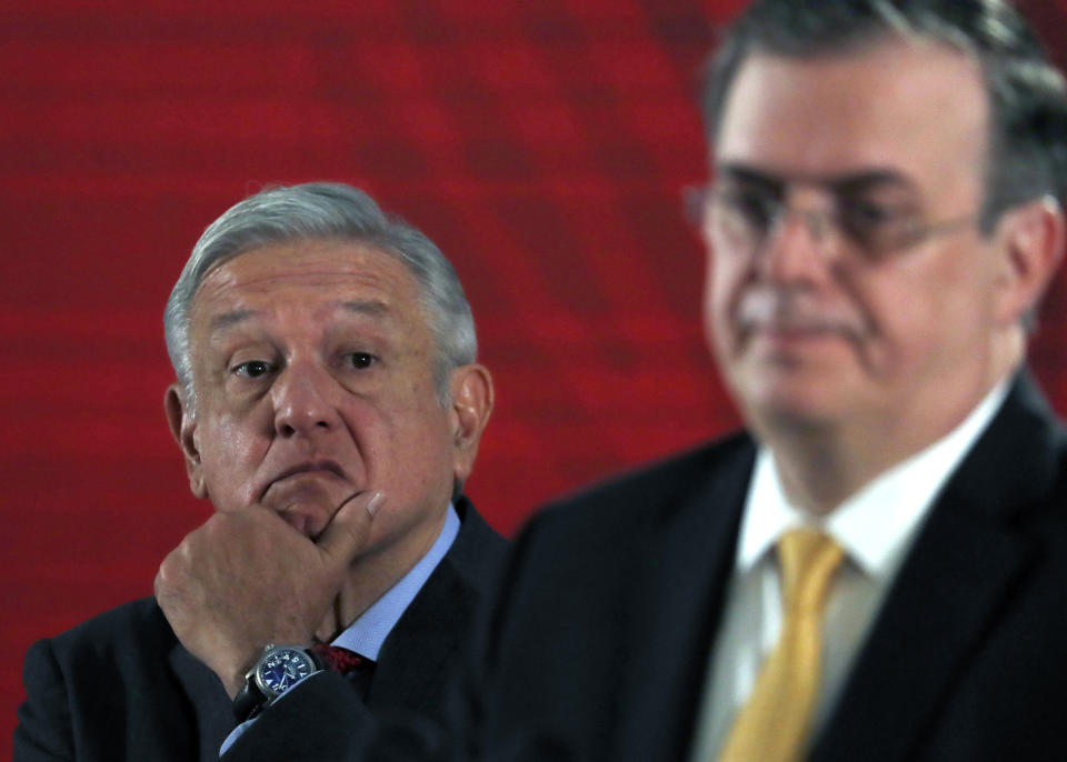 Mexican President Andres Manuel Lopez Obrador watches as his Foreign Minister, Marcelo Ebrard, answers questions from the press during the president's daily morning press conference at the National Palace in Mexico City, Tuesday, Nov. 12, 2019. Bolivia's former President Evo Morales flew out of Bolivia on a Mexican government plane late Monday hours after being granted asylum. (AP Photo/Marco Ugarte)