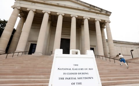 A man works out in front of the National Gallery of Art which is closed due to the partial government shutdown in Washington - Credit: REUTERS/Kevin Lamarque