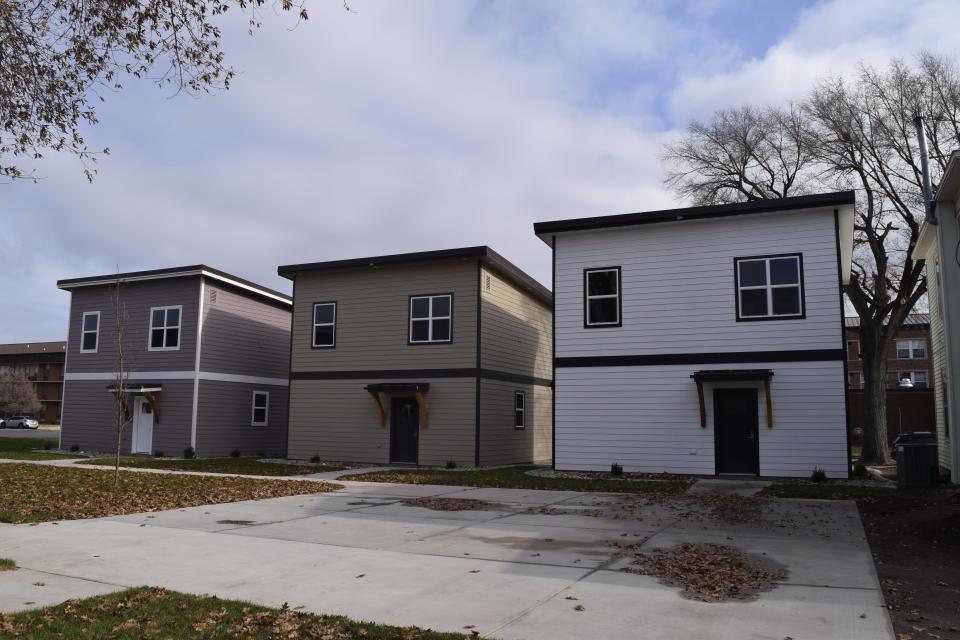 Three small housing buildings that are part of the new Coyote Village sit at the corner of Claflin and Highland Avenues.