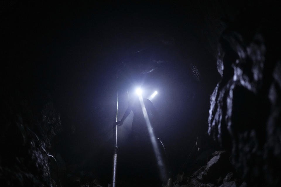 Alfredo Arriojas se ilumina con la lámpara de su cabeza en una mina subterránea de oro en El Callao, estado Bolívar, en Venezuela, el viernes 28 de abril de 2023. Arriojas dijo que no le gusta la minería en la que ha trabajado más de dos años con la esperanza de comprarse una casa y un coche para su familia y el dinero que le sobre invertirlo en algo bueno que le deje un ingreso. (AP Foto/Matias Delacroix)