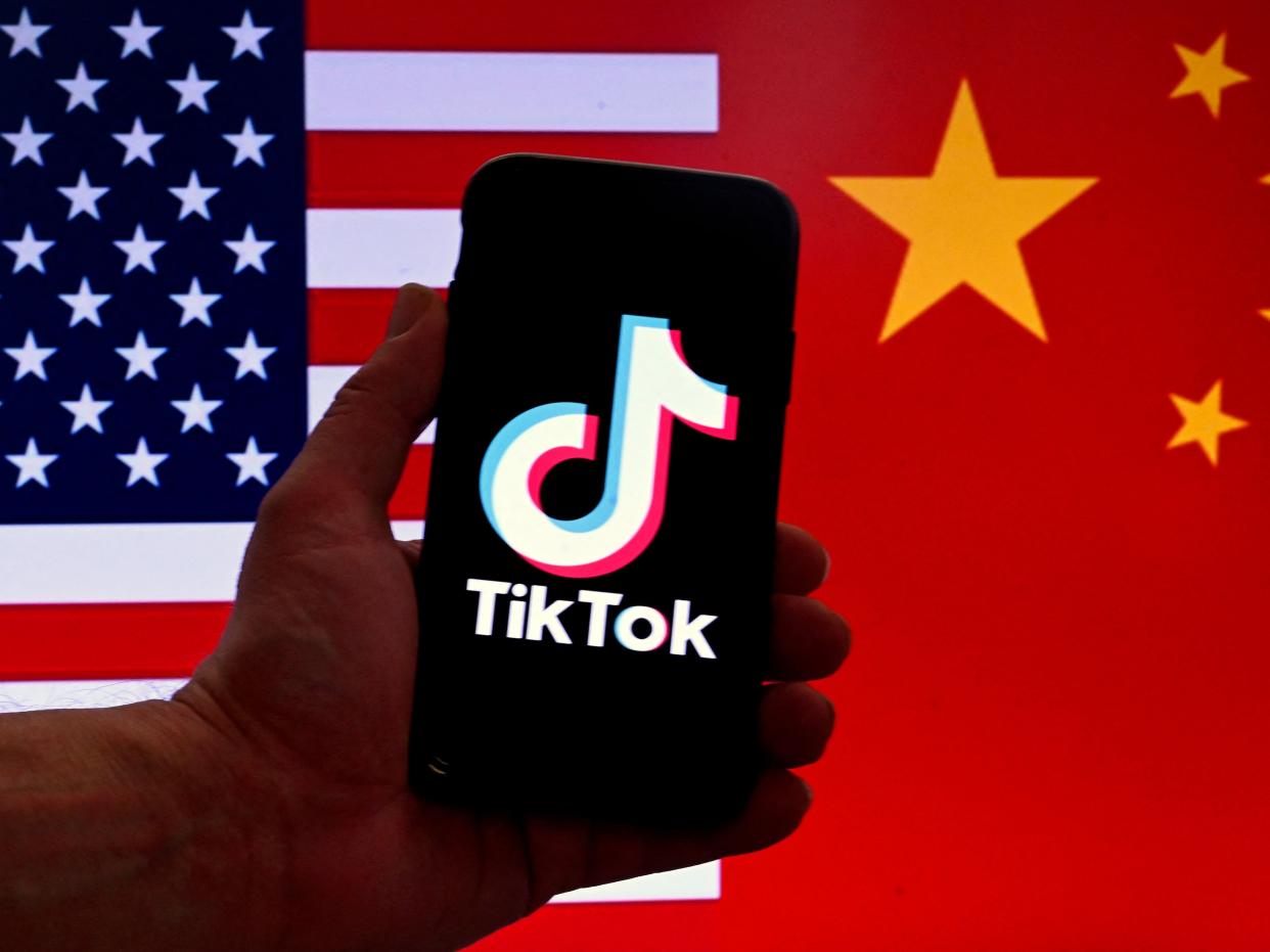 In this photo illustration the social media application logo for TikTok is displayed on the screen of an iPhone in front of a US flag and Chinese flag background in Washington, DC, on March 16, 2023. - China urged the United States to stop "unreasonably suppressing" TikTok on March 16, 2023, after Washington gave the popular video-sharing app an ultimatum to part ways with its Chinese owners or face a nationwide ban. (Photo by OLIVIER DOULIERY / AFP) (Photo by OLIVIER DOULIERY/AFP via Getty Images)