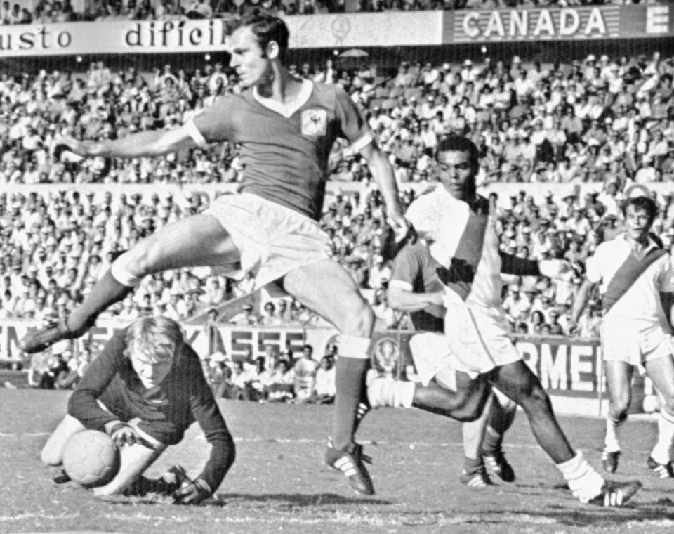 FILE - West German goalkeeper Sepp Maier, left on ground, assisted by Franz Beckenbauer stop an attack during the Football World Cup match between West Germany and Peru, in Leon, Mexico on June 10, 1970. Germany's World Cup-winning coach Franz Beckenbauer has died. He was 78. Beckenbauer was one of German soccer's central figures. He captained West Germany to the World Cup title in 1974. He also coached the national side for its 1990 World Cup win against Argentina. (AP Photo/Lohmann, File)