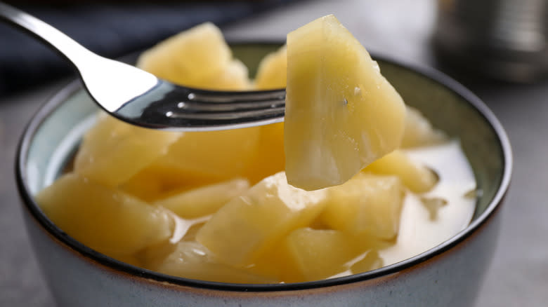 fork spearing canned pineapple chunk