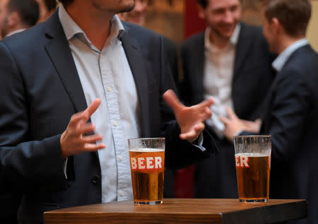 FILE PHOTO: Workers drink outside of a pub in the City of London in London, Britain, October 18, 2017. REUTERS/Toby Melville