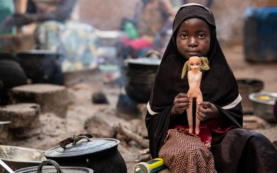 A girl plays with her doll, IDP camp on the outskirts of Ouagadougou  - Simon Townsley/The Telegraph