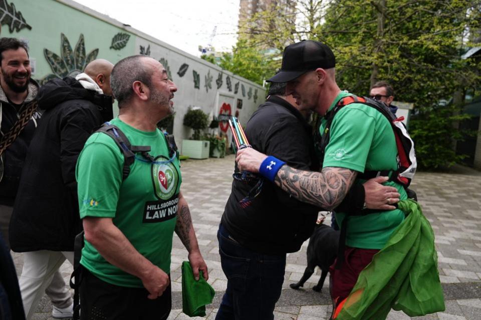 The Northern Echo: Mik Parkin is congratulated after finishing his charity run for the Hillsborough Law campaign, from Liverpool to London at Grenfell Tower