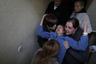 <p>Soledad Carrasquilla Delgado, 53, gets help from her daughter, sister, husband and two members of the Mortgage Victims Platform (PAH) as she faints during a panic attack following the postponement of her family’s eviction in Madrid, Oct. 30, 2013. (AP Photo/Andres Kudacki) </p>