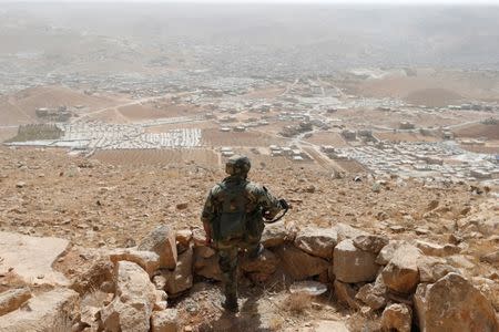 FILE PHOTO: A Lebanese soldier carries his weapon as he stands at an army post in the hills above the Lebanese town of Arsal, near the border with Syria, Lebanon September 21, 2016. Picture taken September 21, 2016. REUTERS/Mohamed Azakir/File Photo