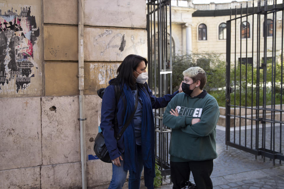 Matteo Coccimiglio talks with Sonia Mugello, a teacher at the Ripetta art Schools in Rome, Wednesday, March 24, 2021. Matteo is an 18-year-old student who identifies as a man and is in the process of changing his legal gender from female to male. The Ripetta school of art in Rome - where he studies - recently joined a handful of high schools in Italy that give transgender students the right to be known by a name other than the one they were given at birth. The initiative is meant to create an environment where transgender students feel secure and reflects a growing awareness in Italy of gender dysphoria among teenagers and children. (AP Photo/Alessandra Tarantino)