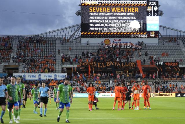 Players and officials leave the field after play was suspended due to severe weather during the first half of an MLS soccer match between the Seattle Sounders and Houston Dynamo Saturday, May 13, 2023, in Houston. (AP Photo/David J. Phillip)
