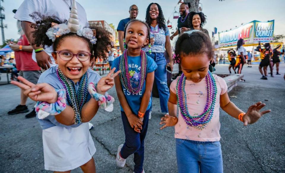 Janelle Graham, 7, Khari McIntosh, 5, Kyla McIntosh, 3, left to right, react after receiving beads on the parade route during the 2024 Miami-Dade County Youth Fair & Exposition. The theme of the 72nd edition is “Spaceventure,” held in Miami on Thursday, March 14, 2024.