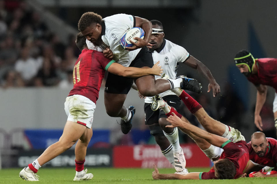 Fiji's Tevita Ikanivere is tackled by Portugal's Rodrigo Marta during the Rugby World Cup Pool C match between Fiji and Portugal, at the Stadium de Toulouse in Toulouse, France, Sunday, Oct. 8, 2023. (AP Photo/Pavel Golovkin)