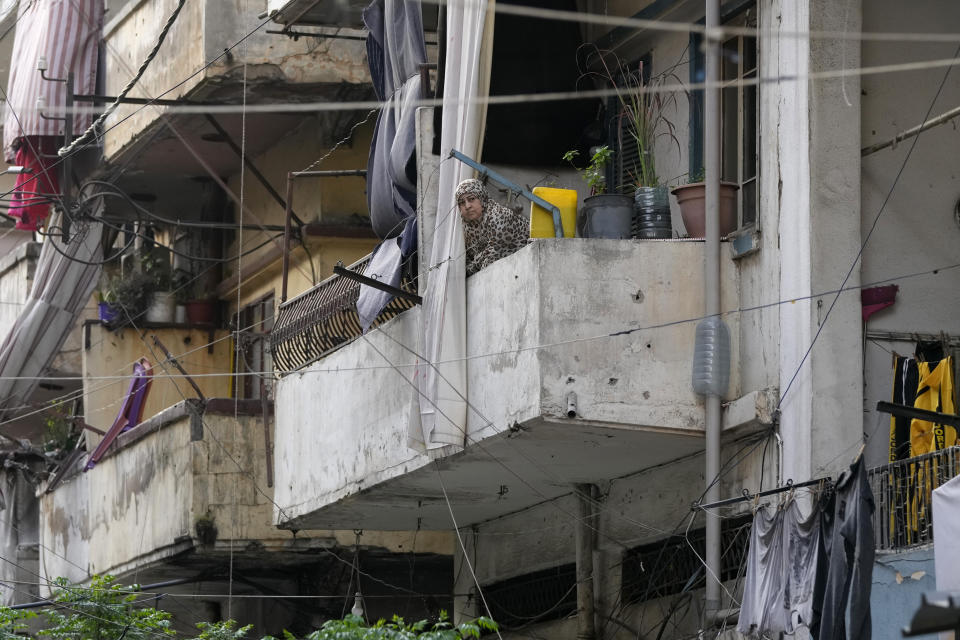 A woman looks from her apartment balcony at Bab al-Tebanneh, one of Tripoli's poorest slums in the northern city of Tripoli, Lebanon, Wednesday, April 27, 2022. A week ago, a boat carrying around 60 Lebanese trying to escape their country and reach Europe sank in the Mediterranean after colliding with a Navy ship. At least seven people are known dead and at least six are missing. The tragedy underscored the desperation among many Lebanese after the collapse of their country's economy. (AP Photo/Hassan Ammar)