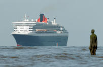 The Queen Mary 2 (QM2) sails past Antony Gormley's 'Another Place' on the approach to the Port of Liverpool on September 15, 2011 in Liverpool, England. The QM2 is visiting Liverpool as part of the city's river festival. The flag ship of Cunard, the QM2 is 1,132 feet in length and is longer than the height of the Eiffel Tower, Westminster’s Tower (Big Ben) and St Paul’s Cathedral. The ship has 14 decks and can host 2,620 guests and 1,253 crew.