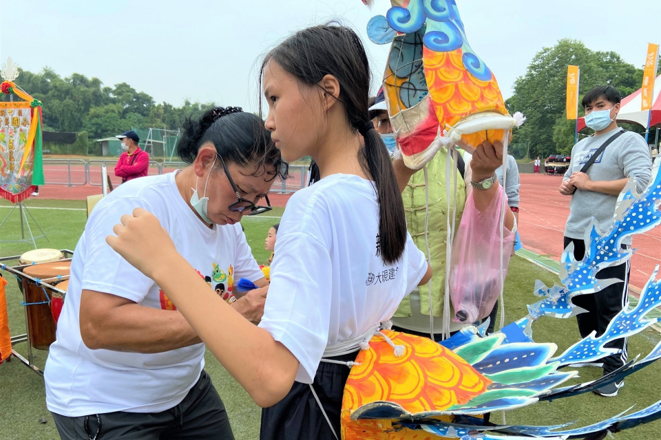 鄭宇芝老師賽前親手幫學生繫緊繩，如給予他們力量及祝福