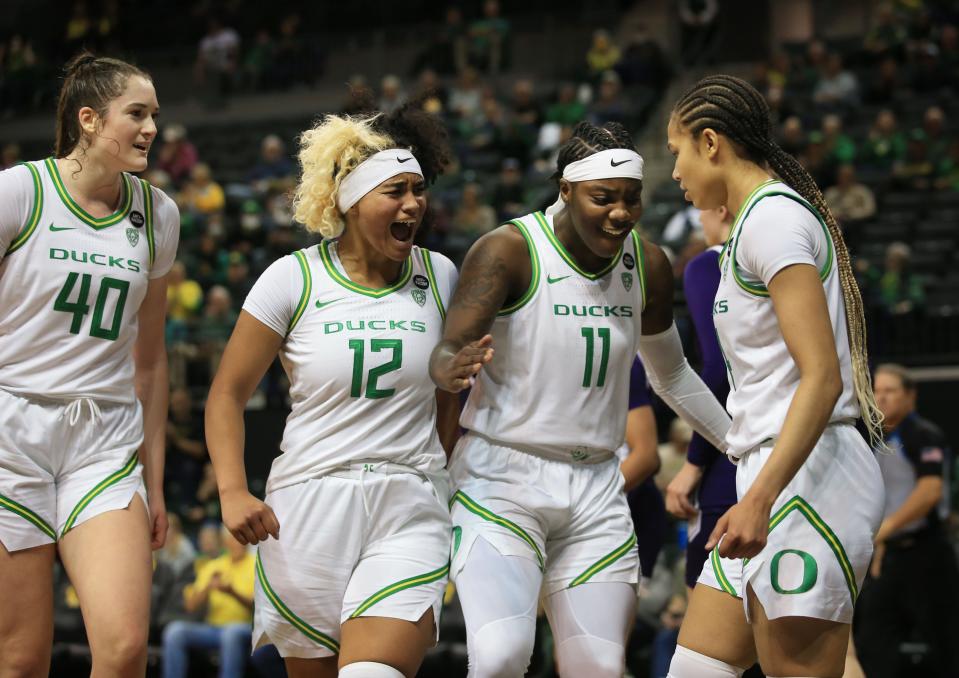 Oregon's Grace VanSlooten, left, Te-Hina Paopao and Taylor Hosendove congratulate Edyia Rogers during the first half against Northwestern at Matthew Knight Arena.