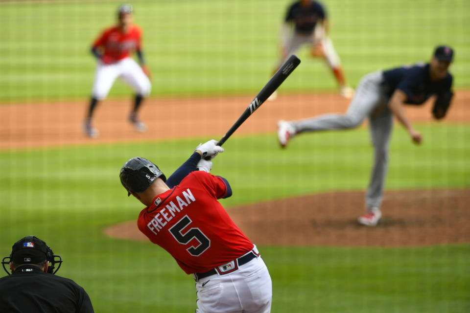 Atlanta Braves' Freddie Freeman lines out to right field on a pitch by Boston Red Sox pitcher Nick Pivetta, right, as Ozzie Albies plays off second base during the fifth inning of a baseball game Sunday, Sept. 27, 2020, in Atlanta. Boston won 9-1. (AP Photo/John Amis)