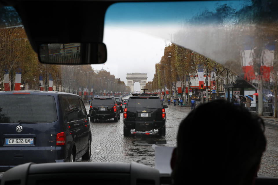 As seen from inside the press vehicle, the motorcade of President Donald Trump drives up the Champs Elysees to an Armistice Day Centennial Commemoration at the Arc de Triomphe, Sunday Nov. 11, 2018, in Paris. As he was arriving, at least one woman ran out toward the presidential motorcade with slogans — including the word FAKE — written on her chest. The woman was stopped by police and the motorcade continued uninterrupted. (AP Photo/Jacquelyn Martin)