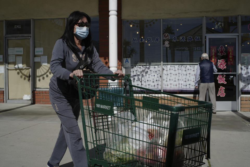 Tien Ngyuen wears a mask as she shops at the 168 Market in Alhambra, Calif., Friday, Jan. 31, 2020. As China grapples with the growing coronavirus outbreak, Chinese people in the Los Angeles area, home to the third-largest Chinese immigrant population in the United States, are encountering a cultural disconnect as they brace for a possible spread of the virus in their adopted homeland. (AP Photo/Damian Dovarganes)