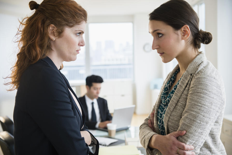 Businesswomen glaring at each other in office