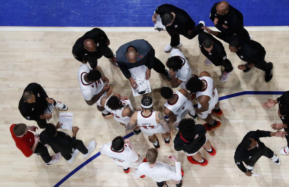 Feb 17, 2024; Pittsburgh, Pennsylvania, USA; Louisville Cardinals head coach Kenny Payne (with broad) draws play in the huddle against the Pittsburgh Panthers during the second half at the Petersen Events Center. Pittsburgh won 86-59. Mandatory Credit: Charles LeClaire-USA TODAY Sports