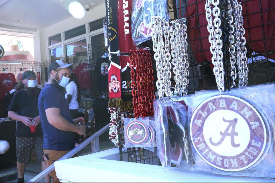 CORRECTS YEAR TO 2021 INSTEAD OF 2020 - Football fans shop for souvenirs, Sunday, Jan. 10, 2021, in Miami Beach, Fla. Ohio State, and Alabama will play the College Football Playoff National Championship game in Miami Gardens on Monday night. (AP Photo/Marta Lavandier)