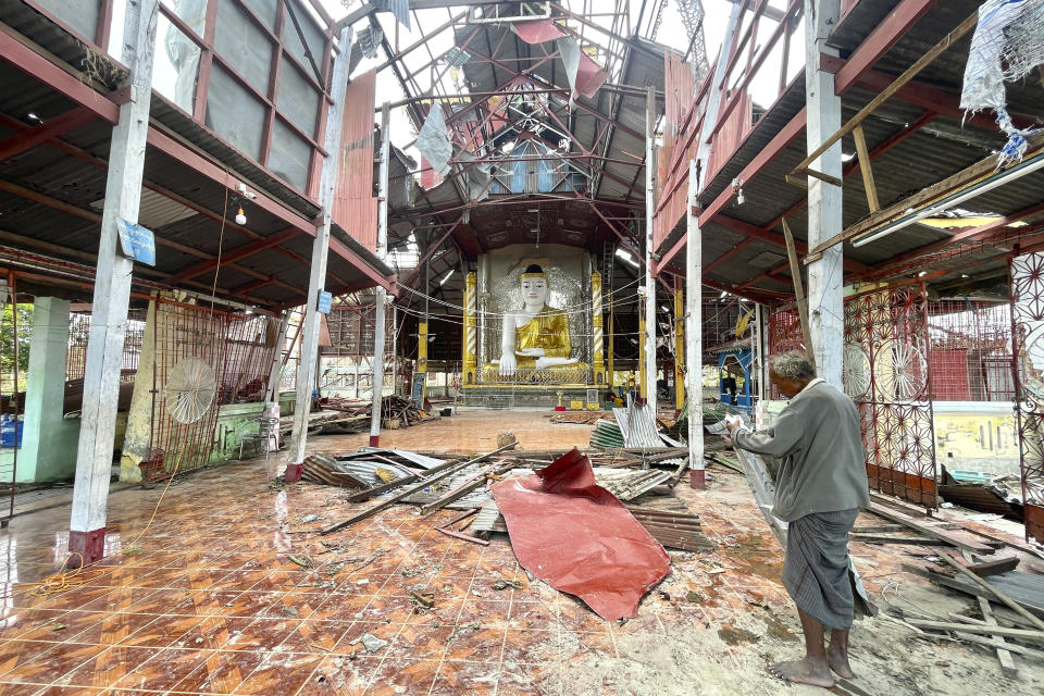 An ethnic Rakhine man stands inside a damaged pagoda to help for repairing roof after Cyclone Mocha in Sittwe township, Rakhine State, Myanmar, Friday, May 19, 2023. Cyclone Mocha roared in from the Bay of Bengal on Sunday with high winds and rain slamming a corner of neighboring Bangladesh and a wider swath of western Myanmar's Rakhine state.(AP Photo)