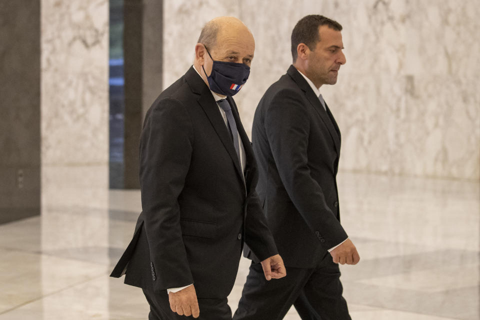 French Foreign Minister Jean-Yves Le Drian, left, wearing a mask to help prevent the spread of the coronavirus, arrives to meet Lebanese president Michel Aoun at the Presidential Palace in Baabda, east of Beirut, Lebanon, Thursday, July 23, 2020. (AP Photo/Hassan Ammar)