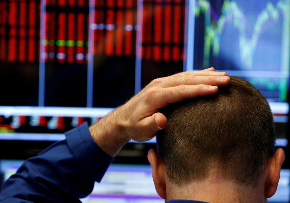 A trader touches his head as he works on the floor of the New York Stock Exchange (NYSE) in New York, U.S., June 24, 2016. REUTERS/Lucas Jackson