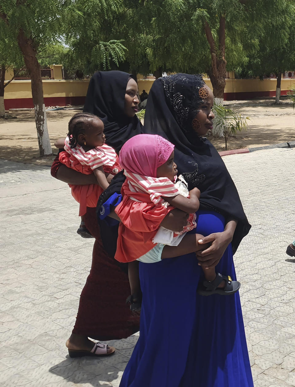 Recently freed Chibok schoolgirls are photographed with their children and government officials at the Army Maimalari Cantonment in Maiduguri, Nigeria, Thursday, May 4, 2023. Two Nigerian schoolgirls have been rescued after nine years in the capacity of a Jihadi militant group, the West African nation's military said Thursday. One girl had a baby while the second was pregnant and gave birth days after her freedom. (AP Photo/Jossy Ola)