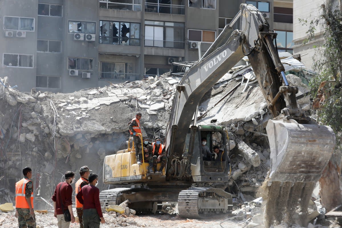 Rescue workers search the rubble of a building used by the Iranian embassy in Damascus after the airstrike (AFP via Getty Images)