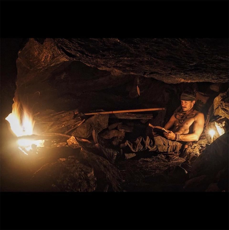 Justin Alexander Shetler inside a cave with fire