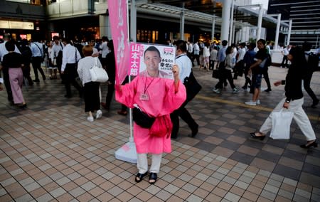 A volunteer holds a poster of Reiwa Shinsengumi's leader and candidate for Japan's July 21 upper house election Taro Yamamoto at an election rally in Tokyo