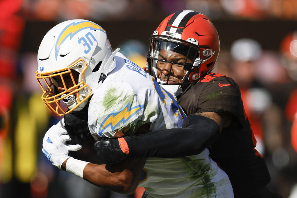 Cleveland Browns safety Grant Delpit (22) hits Los Angeles Chargers running back Austin Ekeler (30) during the second half of an NFL football game, Sunday, Oct. 9, 2022, in Cleveland. (AP Photo/Ron Schwane)