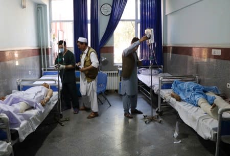 Afghan men receive treatment at a hospital after a bus was hit by a roadside bomb in Herat province