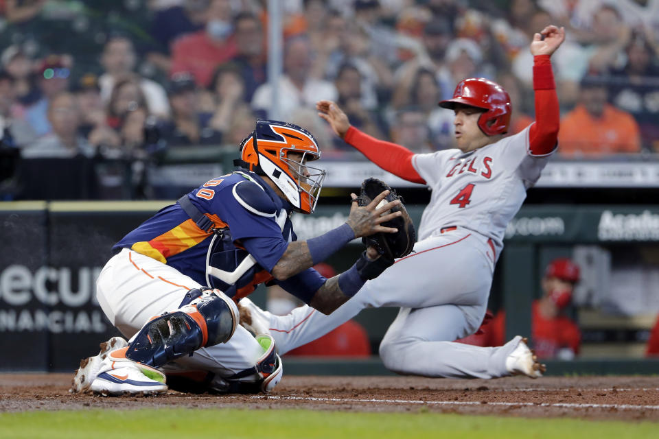 Houston Astros catcher Martin Maldonado, left, tries to make the tag against Los Angeles Angels' Jose Iglesias (4) as he safely slides into home plate during the fifth inning of a baseball game Sunday, April 25, 2021, in Houston. (AP Photo/Michael Wyke)