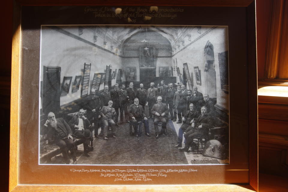 A group of lawmakers gathering in the old Parliament buildings are seen in this historic 1905 photo taken in Wellington, New Zealand as the photo is on display in Parliament. The photo was the basis for a re-enactment by female lawmakers who on Wednesday, Sept. 19, 2018, celebrated the 125th anniversary of New Zealand becoming the first country to give women the right to vote.(AP Photo/Nick Perry)