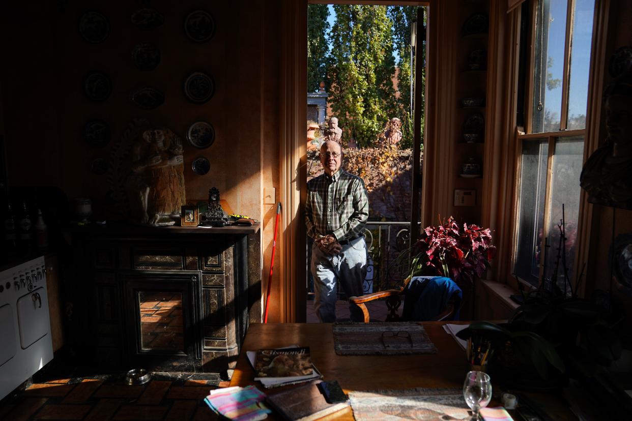 Cincinnati sculptor Ted Gantz stands in the doorway between his kitchen and the Florentine-inspired outdoor space in his Prospect Hill home.