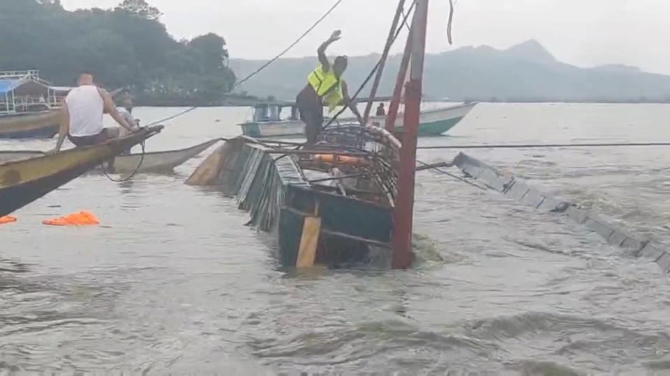 A man stands on the capsized passenger boat in Binangonan, Rizal province (via REUTERS)